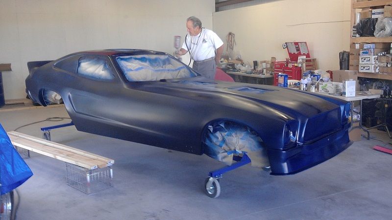 Gary Tuten spraying the color on pop bang boom funny car body