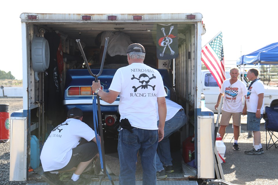 crew of pop bang boom injected nitro funny car loading up the trailer